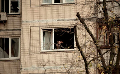 Фото дня: влюблённые целуются на фоне повреждённого окна на Оболони